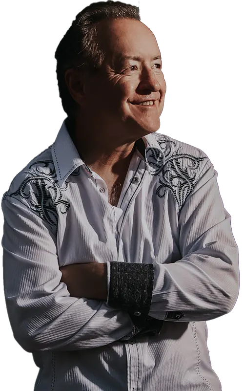 Bobby G. Rice, arms folded, in an embroidered white western shirt