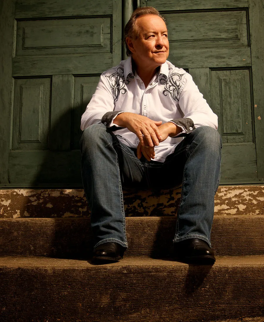 Bobby G. Rice on the steps of a green door, hands folded