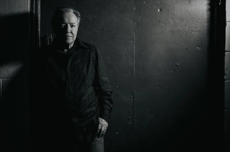 Bobby G. Rice in black and white against a dark wall